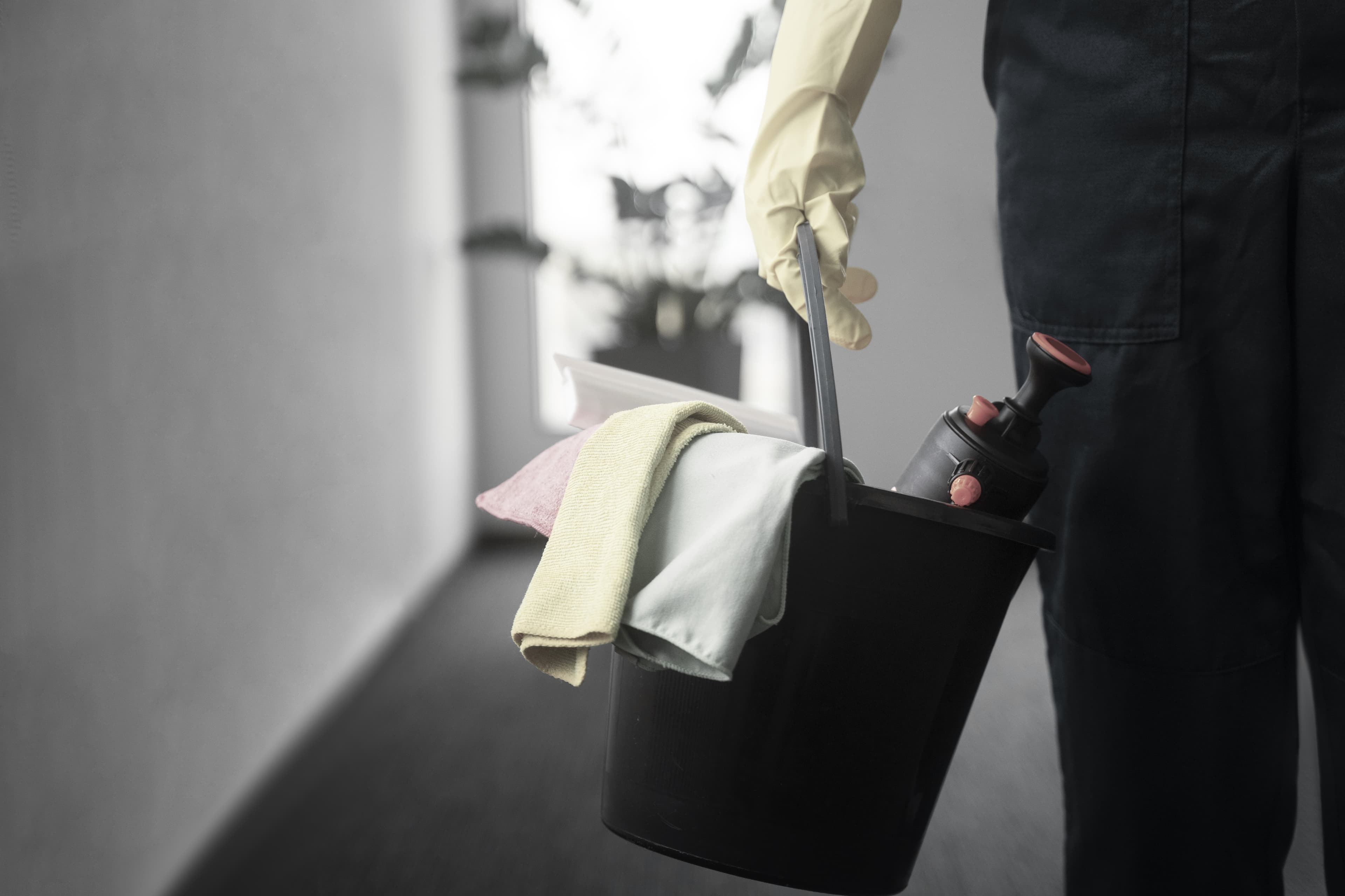 Man in uniform holding commercial cleaning supplies